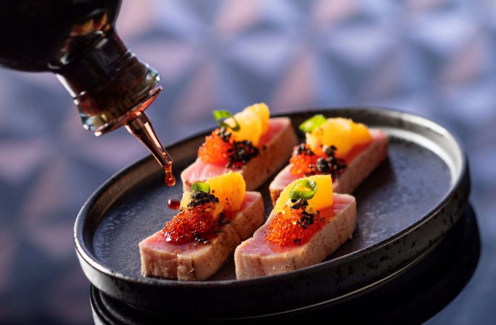 Geo-82 Menu Item: Truffled Ahi Tuna - Japanese whisky barrel-aged soy-truffle ponzu, citrus, scallion, tobiko, and black sesame seeds